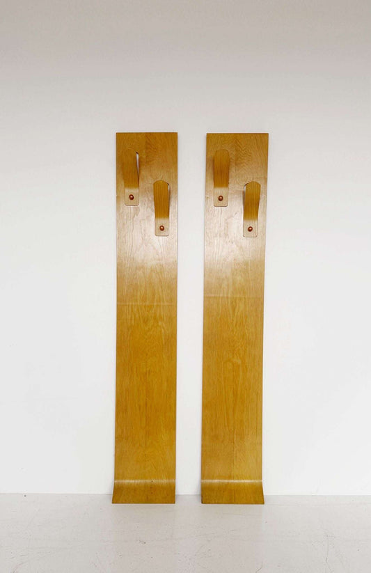 A pair of wall-mounted coat racks composed of two independent vertical modules,