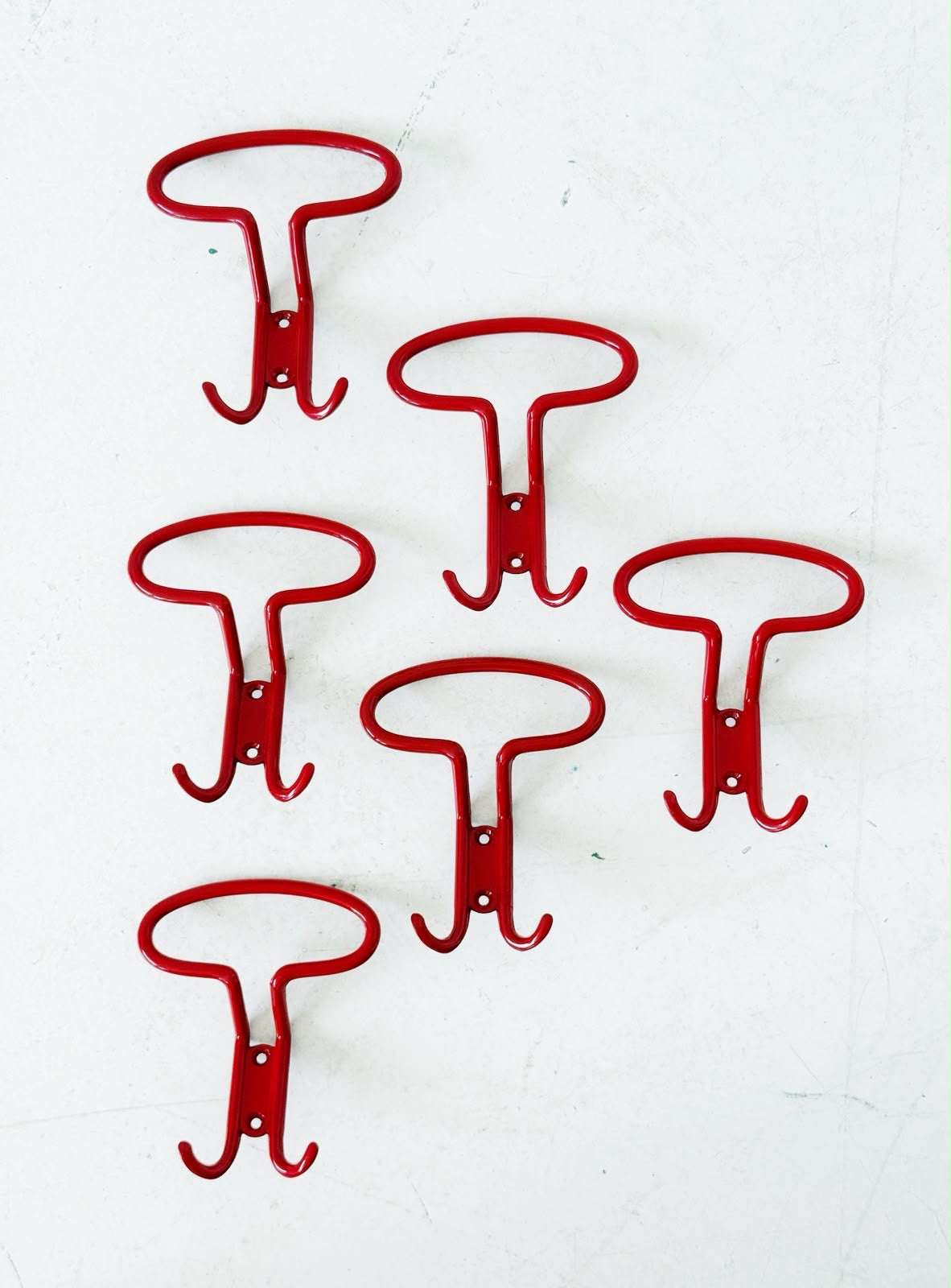 Set of six red metal wall hooks